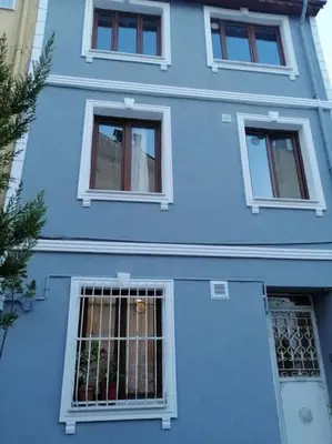 a blue house with three windows and a gate at Historical comfy flat in Beyoğlu tophane, galata in Istanbul