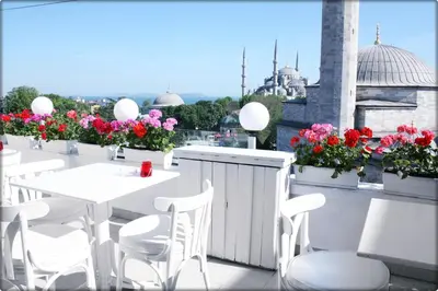 a balcony with white tables and white chairs and flowers at No20 Hotel Sultanahmet in Istanbul