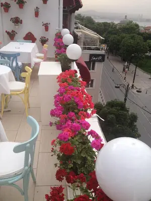a row of flowers on a balcony with tables and chairs at No20 Hotel Sultanahmet in Istanbul