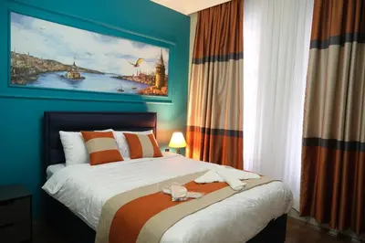 a bedroom with a bed with a painting on the wall at TAKSİM MY HOUSE BUTİK OTEL in Istanbul