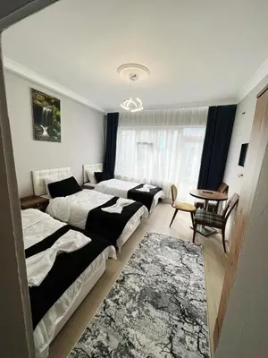 a hotel room with three beds and a couch at Taksim Milenyum Suites in Istanbul