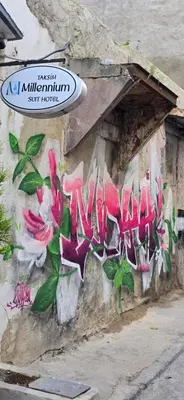 a wall with graffiti on it with flowers on it at Taksim Milenyum Suites in Istanbul