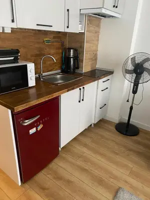 a kitchen with a sink and a microwave and a fan at BEYOĞLU in Istanbul