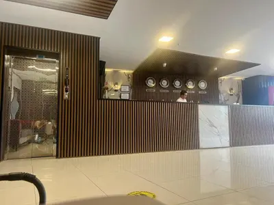 a man standing at a counter with clocks on the wall at E5 PARK OTEL in Esenyurt