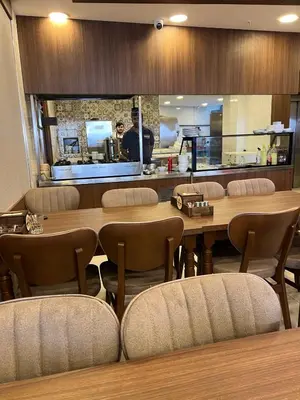a restaurant with a large wooden table and chairs at E5 PARK OTEL in Esenyurt