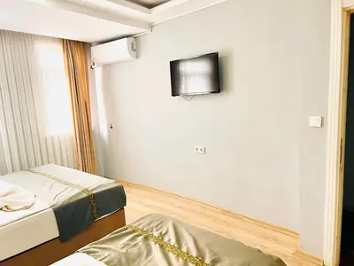 a room with two beds and a tv on the wall at otel grand sami in Istanbul