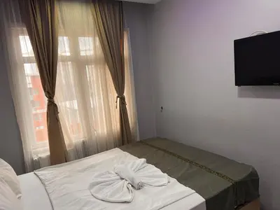 a bed with two towels on it in a room with a window at otel grand sami in Istanbul