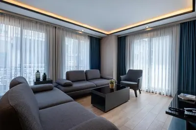 a living room with a couch and chairs and windows at The Row Suites Taksim in Istanbul