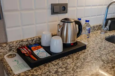 a tea kettle and cups on a tray on a kitchen counter at The Row Suites Taksim in Istanbul