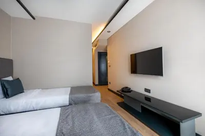 a bedroom with a bed and a tv on a wall at The Row Suites Taksim in Istanbul