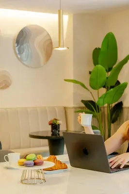 a woman sitting at a table with a laptop computer at The Row Suites Taksim in Istanbul