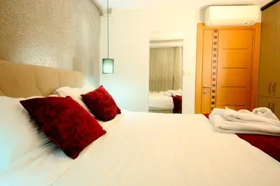 a bedroom with a white bed with red pillows at Taksim Celebi Suites in Istanbul