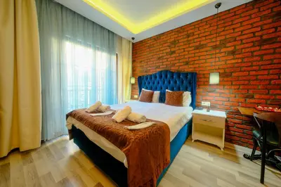 a bedroom with a large bed with a brick wall at Taksim Celebi Suites in Istanbul