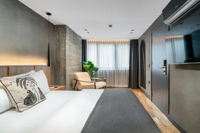 a bedroom with a large white bed and a chair at Urban Quarters - Gülhane in Istanbul