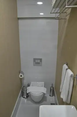 a white bathroom with a toilet and a sink at Miller Hotel in Istanbul