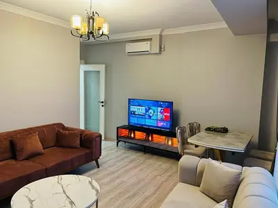 a living room with a couch and a flat screen tv at Cantrmen Suites in Istanbul