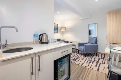 a kitchen with a sink and a living room at The Capri Hotel Osmanbey in Istanbul