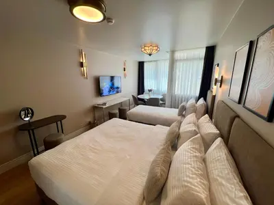 a hotel room with two beds and a desk at Weingart Suites Hotel in Istanbul