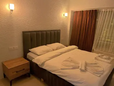 a bedroom with a bed with white sheets and a window at Kadıköy Bull Hotel in Istanbul