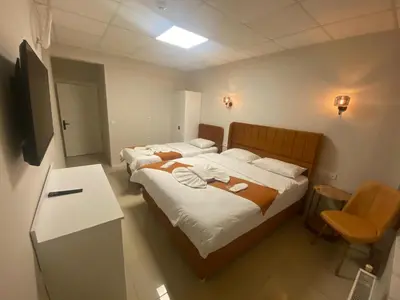 a bedroom with two beds and a table and a chair at Kadıköy Bull Hotel in Istanbul