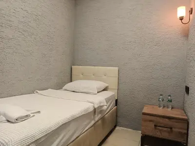 a small bedroom with two beds and a table at Kadıköy Bull Hotel in Istanbul