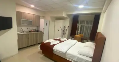 a bedroom with a bed and a kitchen with a sink at Kadıköy Bull Hotel in Istanbul