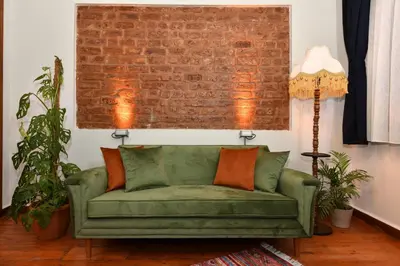 a green couch in a living room with a brick wall at Historical Levantine Flat @Heart of Taksim in Istanbul