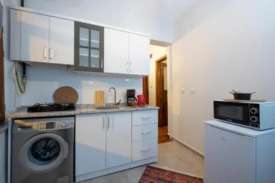 a kitchen with white cabinets and a washing machine at Historical Levantine Flat @Heart of Taksim in Istanbul