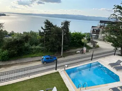 a blue car is parked next to a swimming pool at White Home Sapanca in Sapanca