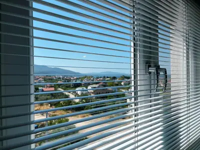a window with blinds on it with a view of a city at Doğanın Kalbindeki Eviniz-7 Kişi in Gemlik
