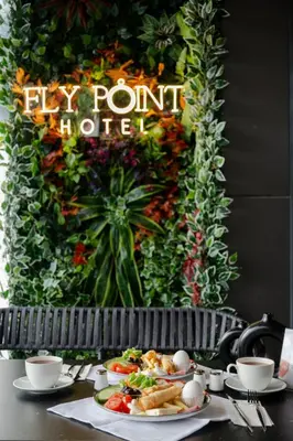 a table with a plate of food and a sign that says fly point hotel at FLY POINT AIRPORT HOTEL in Arnavutköy
