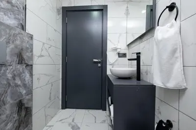 a bathroom with a black door and a sink at FLY POINT AIRPORT HOTEL in Arnavutköy