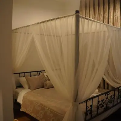 a canopy bed with white curtains in a bedroom at GALATA KULESİ yakınında geniş 3+1 tarihi daire in Istanbul