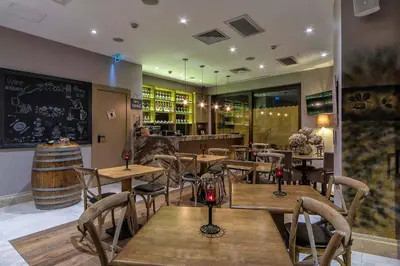 a restaurant with wooden tables and chairs and a chalkboard at Hotel Morione & Spa Center in Istanbul