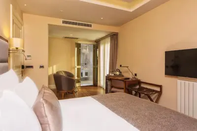 a hotel room with a bed and a desk and a television at Hotel Morione & Spa Center in Istanbul