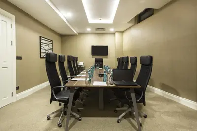 a conference room with a long table with chairs and a laptop at Hotel Morione & Spa Center in Istanbul