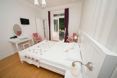 a white bedroom with a bed and a desk at Cenar Konak Butik Hotel in Buyukada