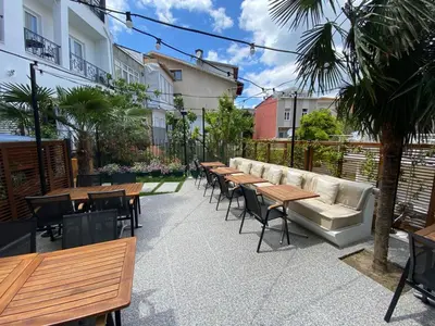 a patio with tables and chairs and a couch at Cenar Konak Butik Hotel in Buyukada