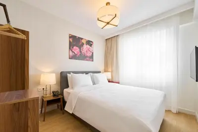 a bedroom with a large white bed and a window at The Marmara Camlica in Istanbul