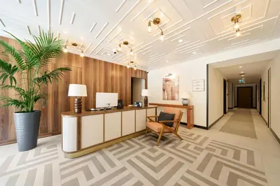 an office lobby with a reception desk and a plant at The Marmara Camlica in Istanbul