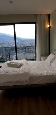 a bedroom with a bed and a large window at فلل التن تاج ALTINTAC villalari in Sapanca