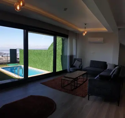 a living room with a couch and a view of a pool at فلل التن تاج ALTINTAC villalari in Sapanca