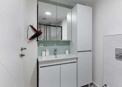 a white bathroom with a sink and a mirror at Allegro Apartments Kadıköy in Istanbul