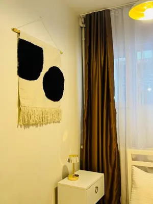 a bedroom with a curtain and a table with a lamp at Дуплекс с видом на Босфор in Istanbul