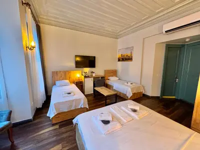 a hotel room with two beds and a tv at Otel Kadıköy in Istanbul