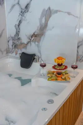 a bath tub with two glasses of wine and a plate of food at Sapanca Kokina Suit in Sakarya