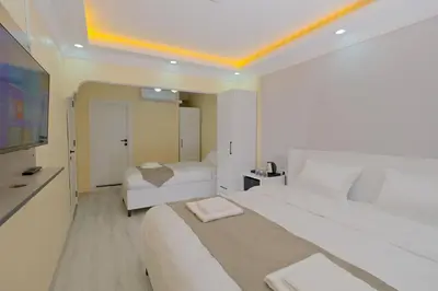 a hotel room with two beds and a flat screen tv at Lucky Hotel İstanbul in Istanbul