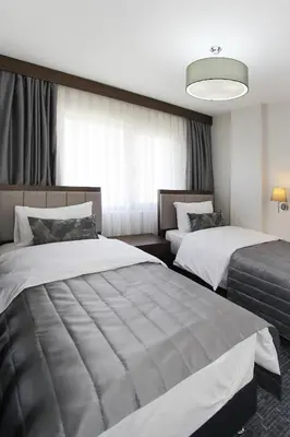 a hotel room with two beds and a large window at Pisa Hotel in Istanbul