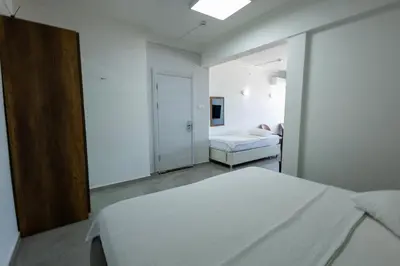 a white room with a bed and a bedroom with a mirror at Karamürsel Mohti Otel Fitness Organizasyon in Karamusal