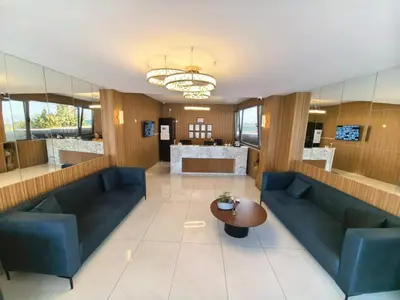 a lobby with blue couches and a table at Karamürsel Mohti Otel Fitness Organizasyon in Karamusal